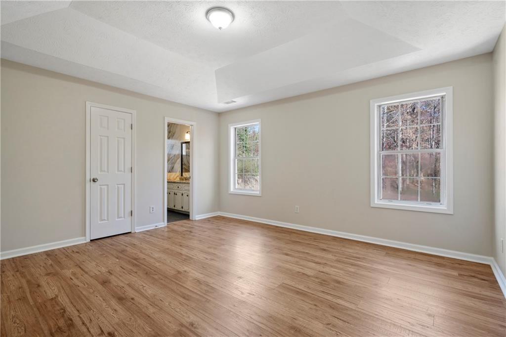 3323 Old Oaks Road Buford, GA 30519 - Photo 14 of 24 a view of an empty room with wooden floor and a window