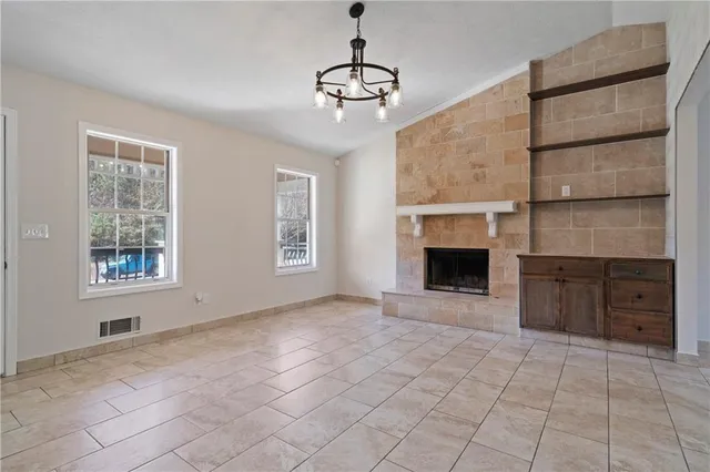 a view of an empty room with a window and fireplace