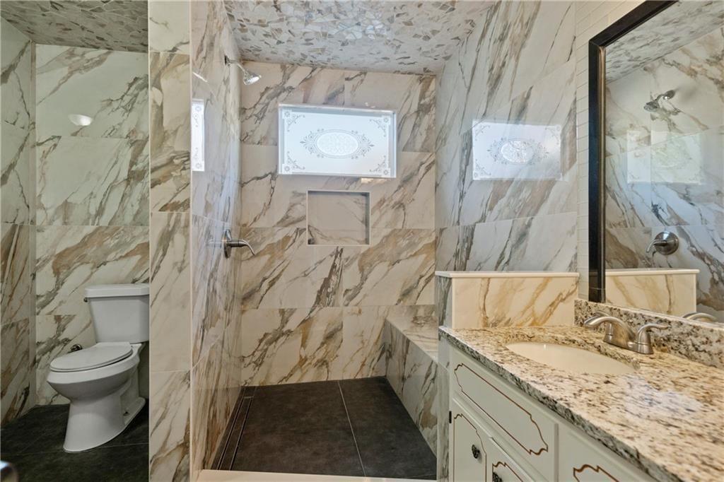 3323 Old Oaks Road Buford, GA 30519 - Photo 16 of 24 a bathroom with a granite countertop sink and a toilet