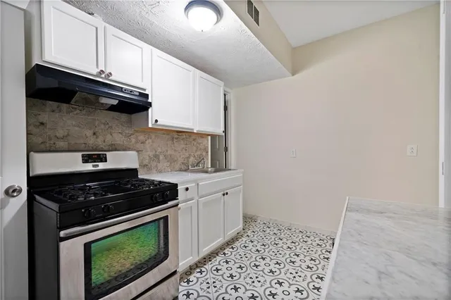 a kitchen with granite countertop cabinets and stove