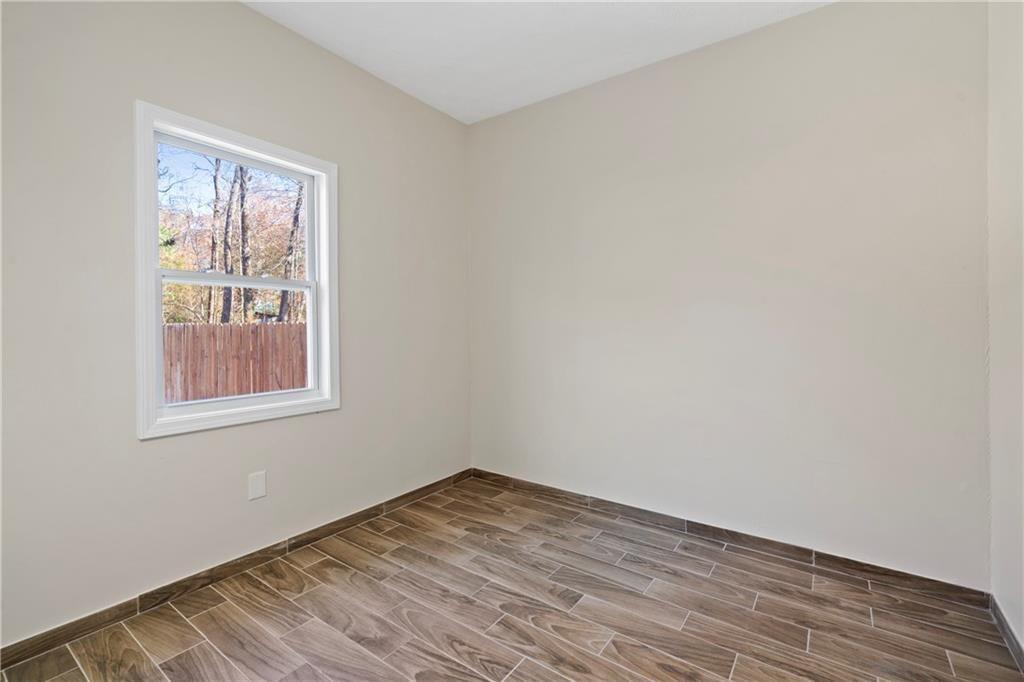 3323 Old Oaks Road Buford, GA 30519 - Photo 22 of 24 a view of an empty room with wooden floor and a window