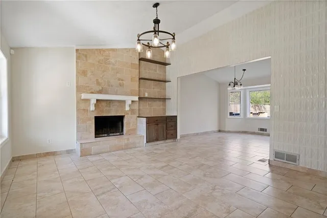 a view of an empty room with a fireplace and a window