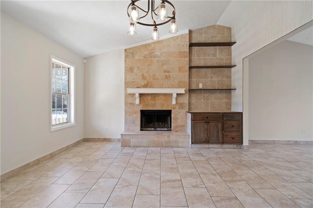 3323 Old Oaks Road Buford, GA 30519 - Photo 6 of 24 a view of an empty room with a fireplace and a window