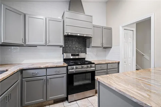 a kitchen with granite countertop a stove and a sink