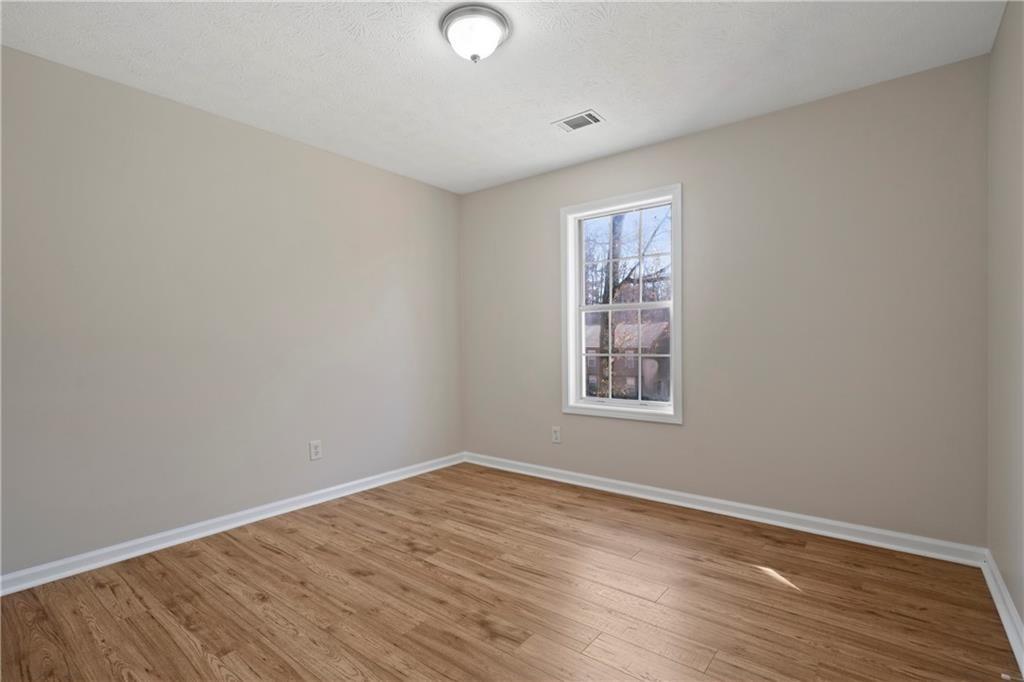 3323 Old Oaks Road Buford, GA 30519 - Photo 10 of 24 an empty room with wooden floor and windows