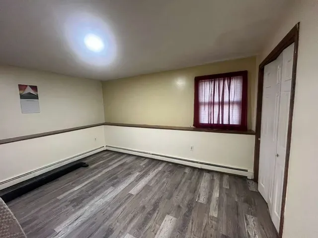 wooden floor in an empty room with a window