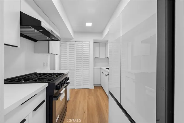 a kitchen with stainless steel appliances a refrigerator a sink and wooden floor