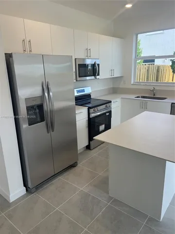 a kitchen with stainless steel appliances a refrigerator sink and microwave