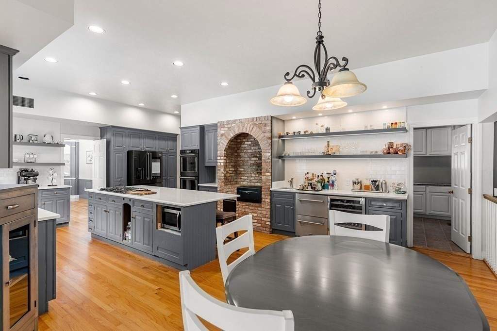 3 Burnham Lane Danvers, MA 01923 - Photo 5 of 41 a kitchen with stainless steel appliances granite countertop a stove top oven a refrigerator a sink and a dining table with wooden floor