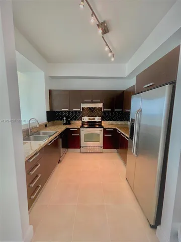 a kitchen with stainless steel appliances granite countertop a stove a refrigerator and a sink