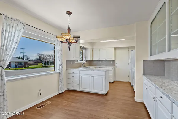 a view of a livingroom with wooden floor a ceiling fan and window