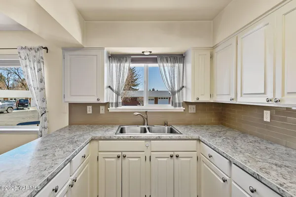 a kitchen with stainless steel appliances white cabinets and white appliances