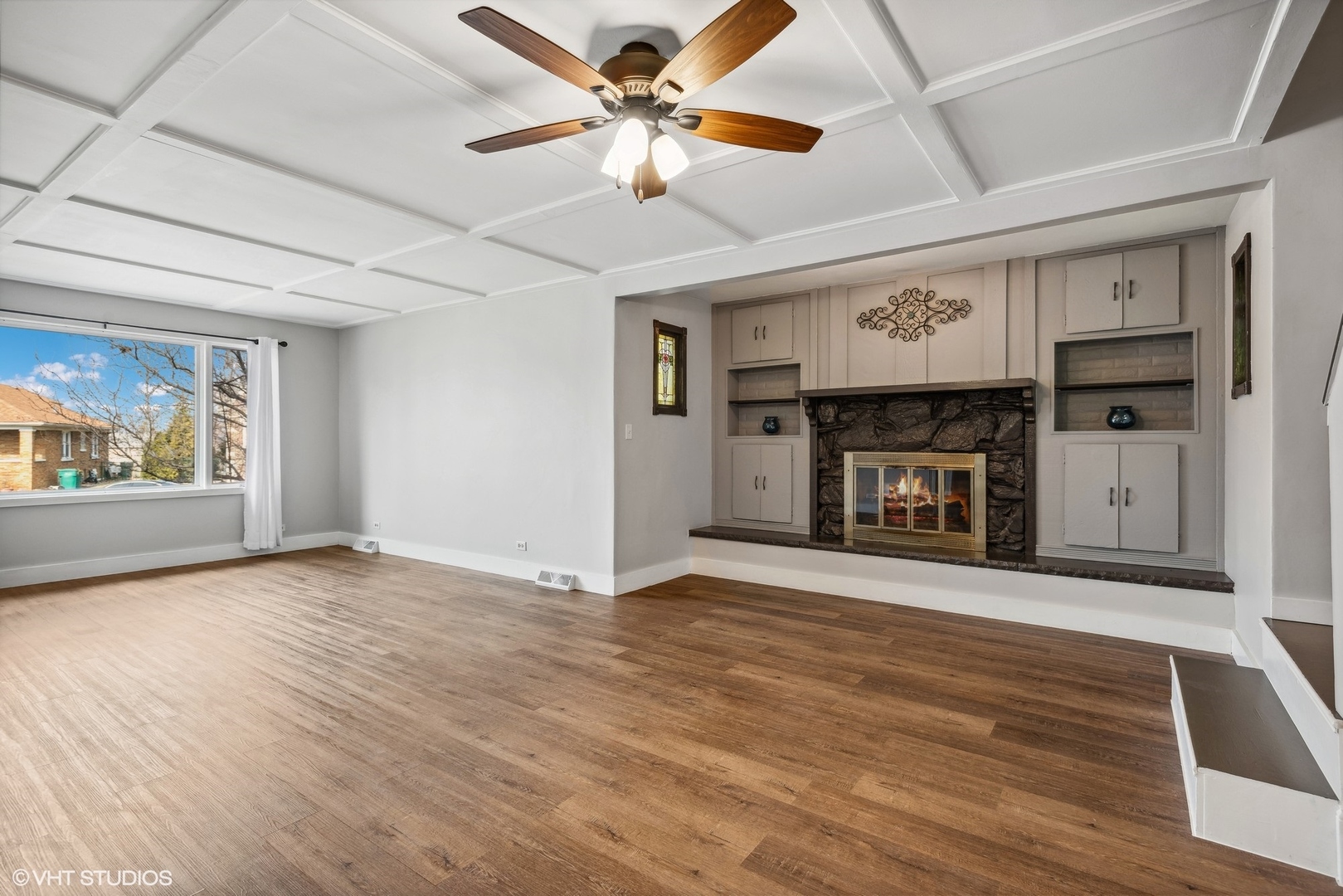 712 McCarthy Road Lemont, IL 60439 - Photo 8 of 24 an empty room with windows fireplace and a ceiling fan