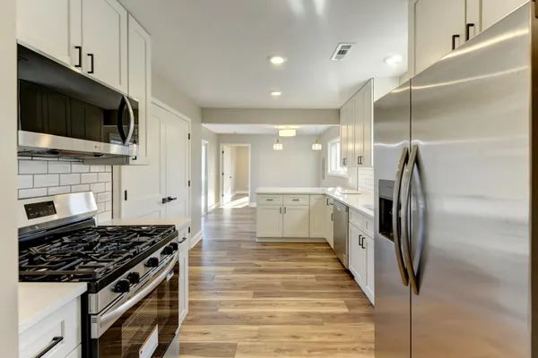 a kitchen with stainless steel appliances kitchen island granite countertop a stove and a refrigerator