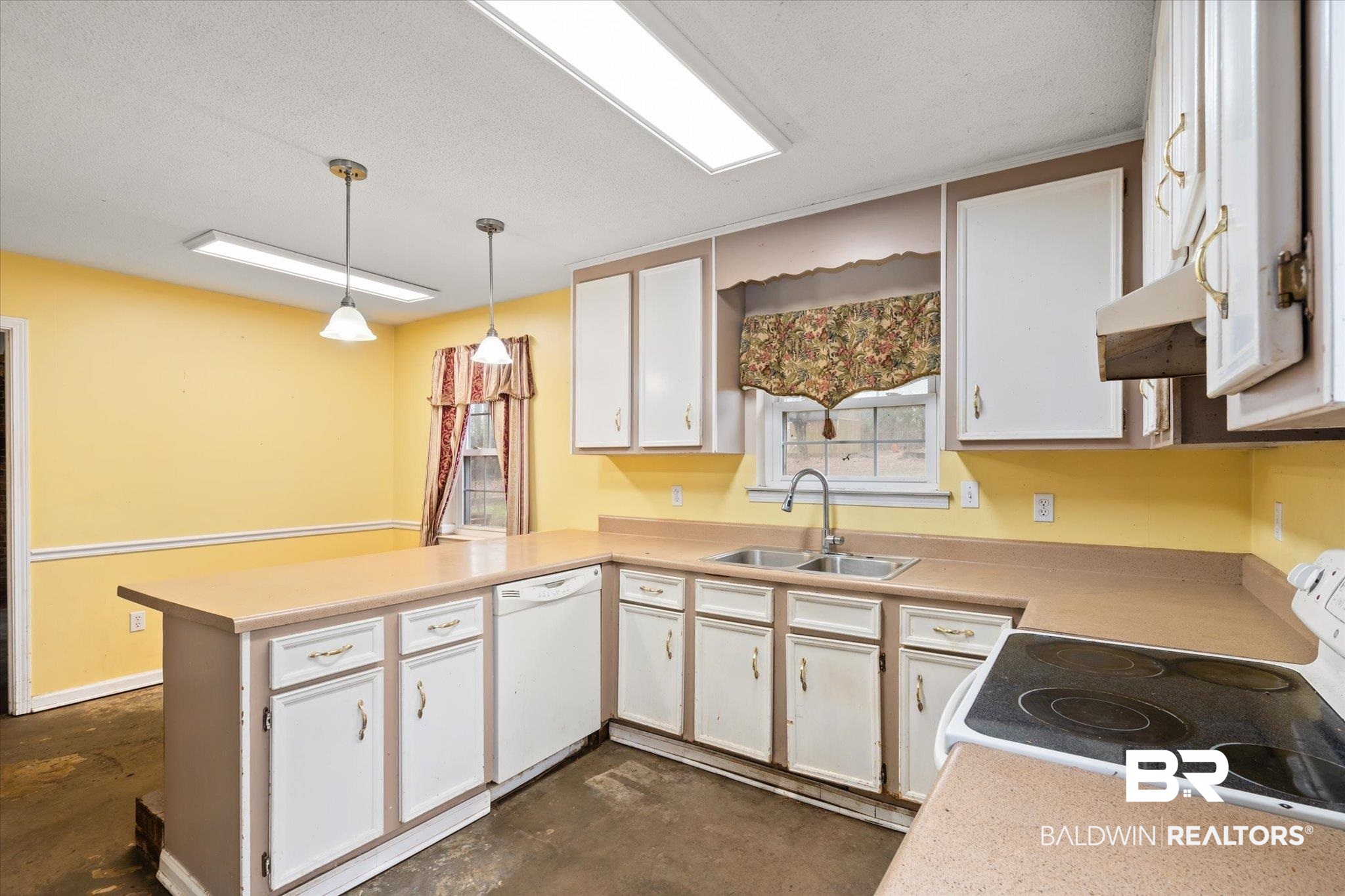 3541 Winston Drive Semmes, AL 36575 - Photo 5 of 20 Kitchen with a peninsula, white appliances, a sink, white cabinetry, and pendant lighting