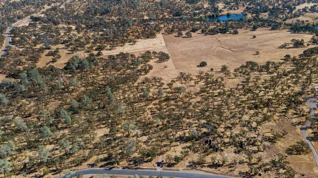 an aerial view of house with yard and mountain view in back