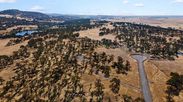 an aerial view of house with yard and mountain view in back