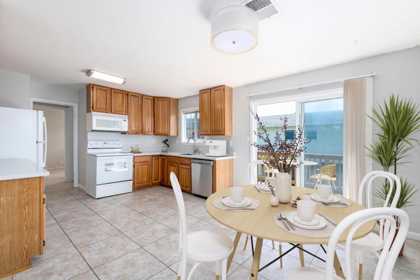 168 Salada Avenue Pacifica, CA 94044 - Photo 2 of 12 a kitchen with a refrigerator a stove a sink dishwasher with a dining table and chairs