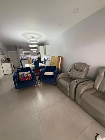 a living room with furniture a counter space and stainless steel appliances