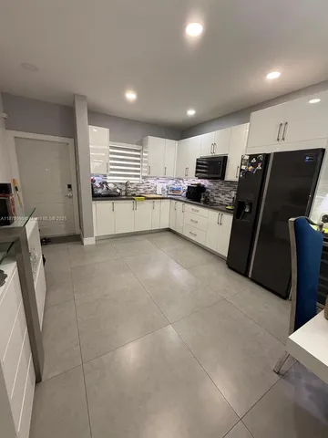 a kitchen with stainless steel appliances a refrigerator and a stove top oven
