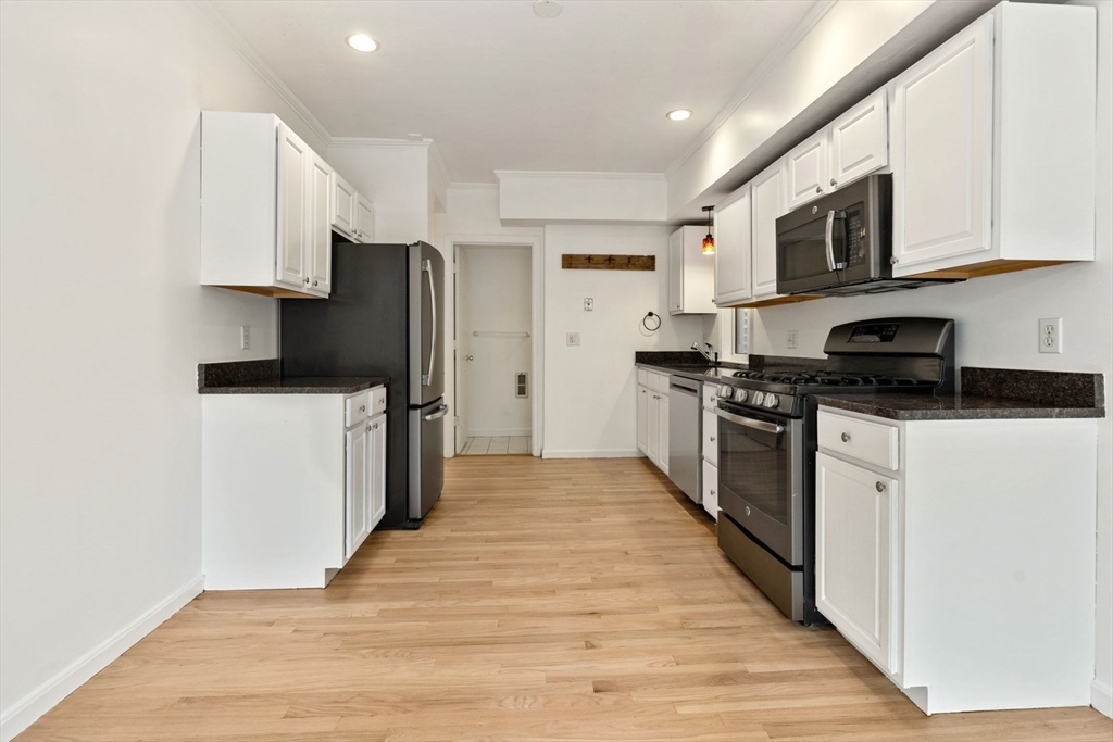 8 Peters Street, Unit B Boston, MA 02127 - Photo 3 of 14 a kitchen with stainless steel appliances a refrigerator stove and microwave
