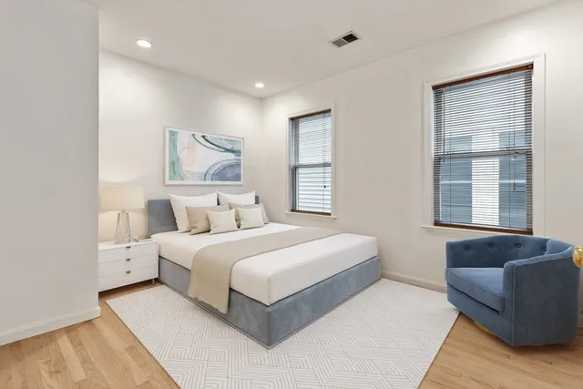 a bedroom with a bed couch and a window