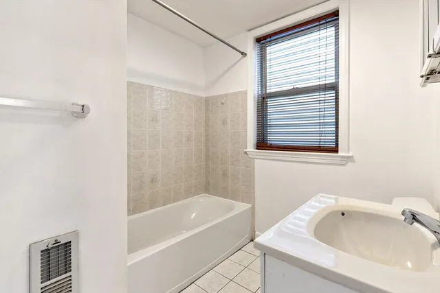 a bathroom with a tub sink and shower