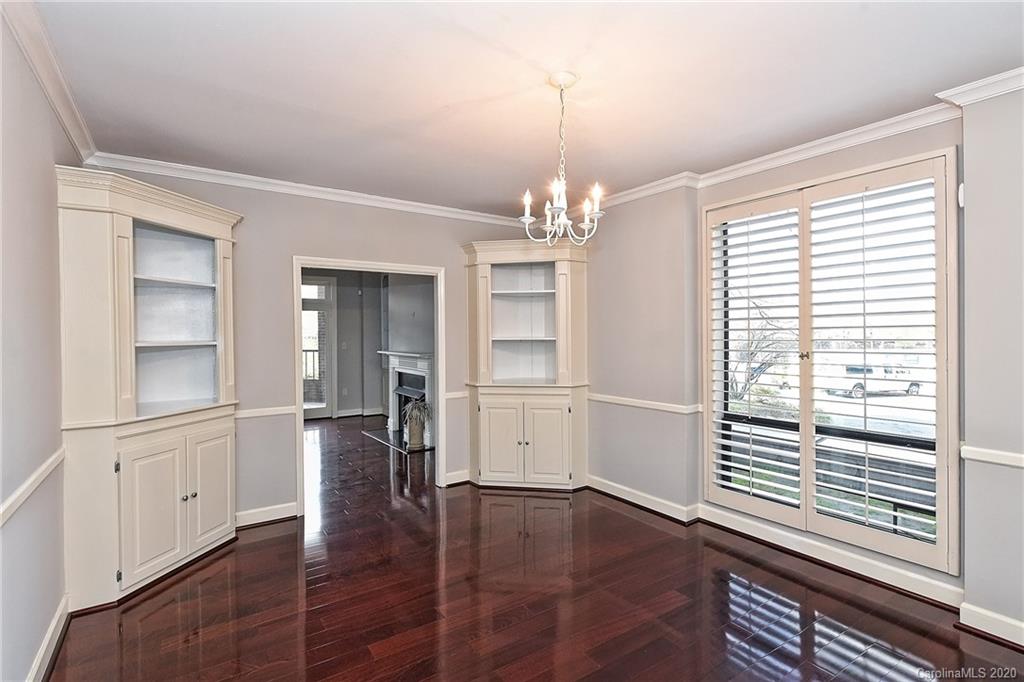 908 Cherokee Road, Unit 908 Charlotte, NC 28207 - Photo 13 of 35 an empty room with wooden floor chandelier and windows