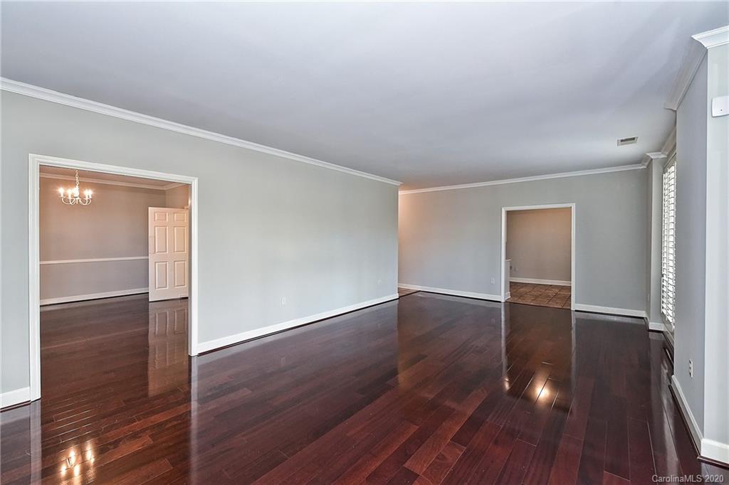 908 Cherokee Road, Unit 908 Charlotte, NC 28207 - Photo 14 of 35 an empty room with wooden floor & cabinet and door