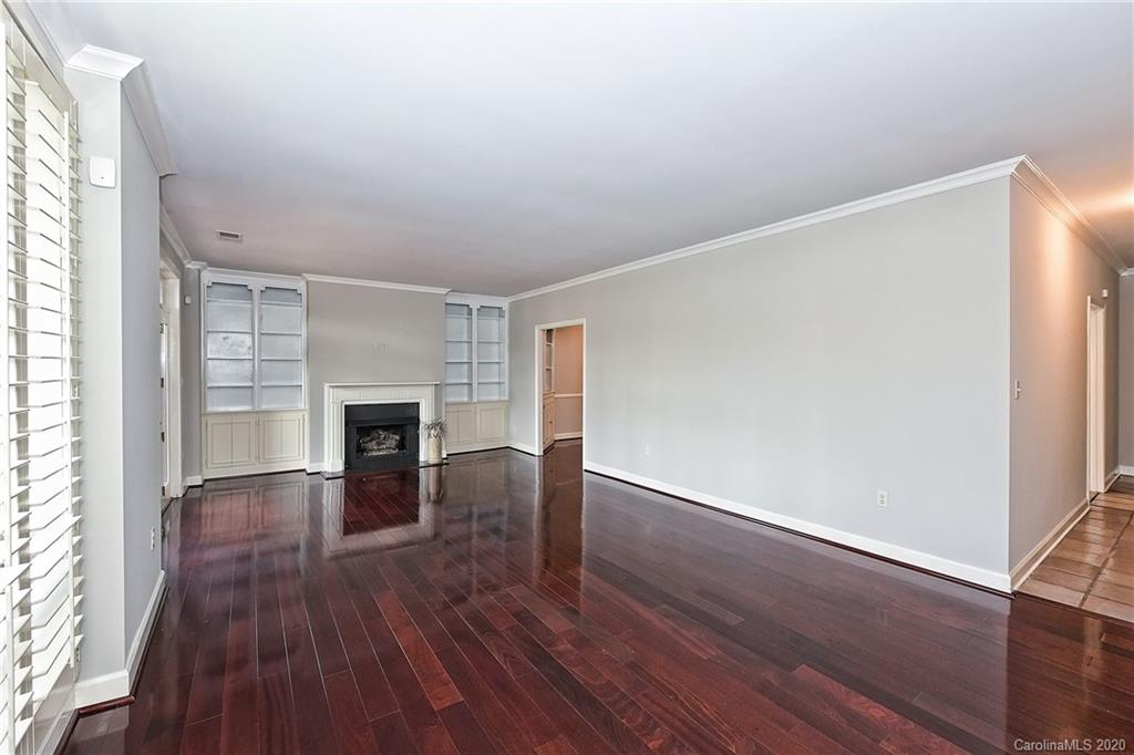 908 Cherokee Road, Unit 908 Charlotte, NC 28207 - Photo 17 of 35 an empty room with wooden floor fireplace and windows