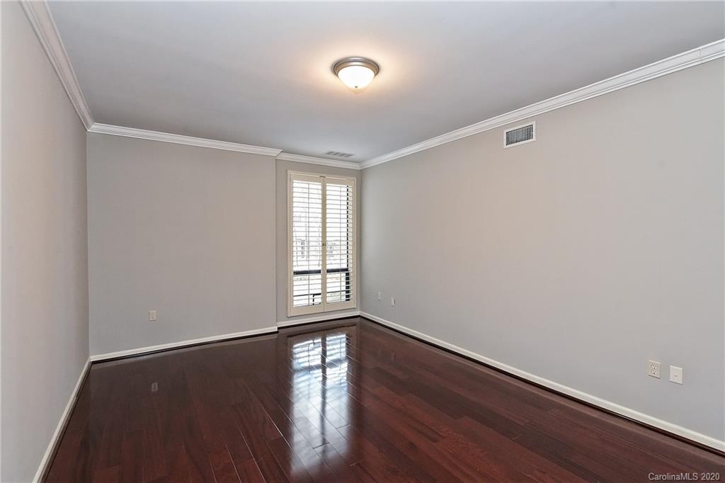 908 Cherokee Road, Unit 908 Charlotte, NC 28207 - Photo 23 of 35 a view of an empty room with wooden floor and a window