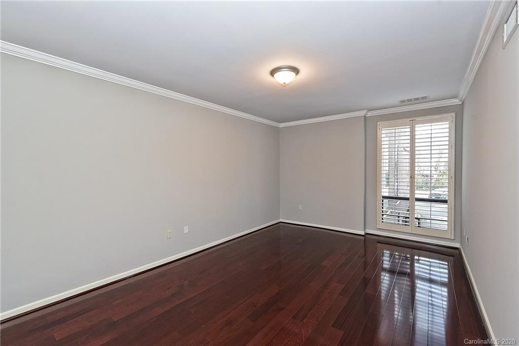 908 Cherokee Road, Unit 908 Charlotte, NC 28207 - Photo 24 of 35 an empty room with wooden floor and windows