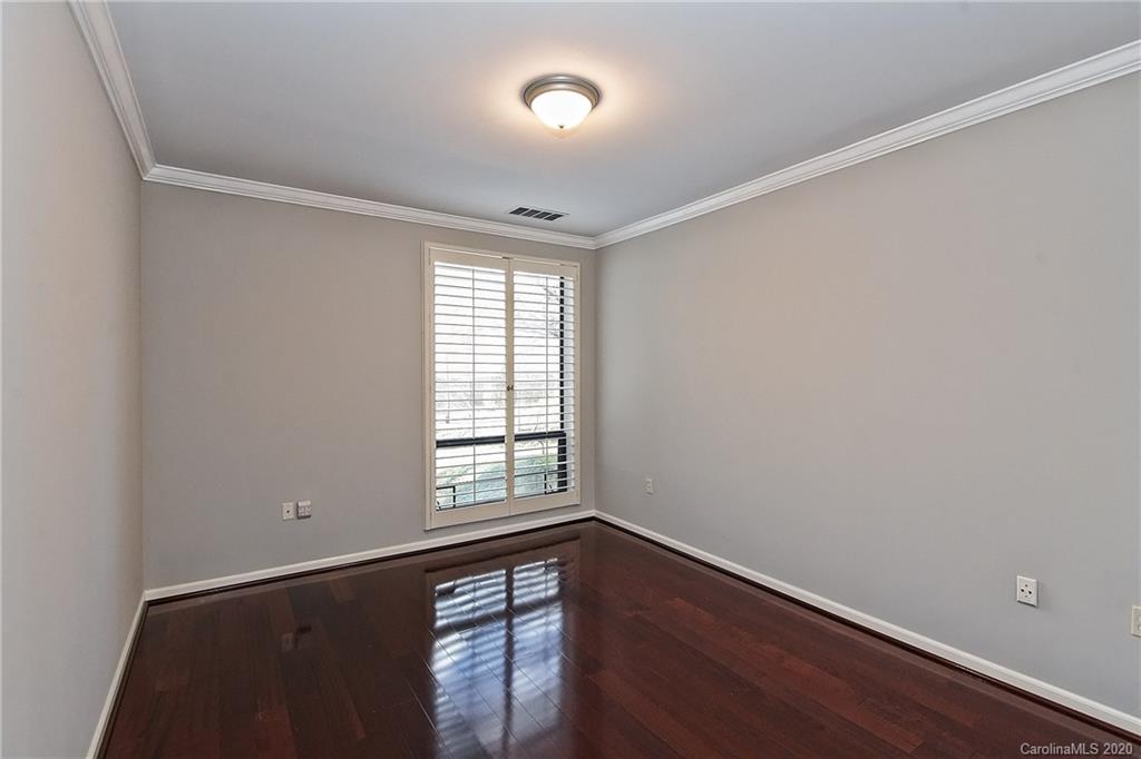 908 Cherokee Road, Unit 908 Charlotte, NC 28207 - Photo 29 of 35 an empty room with wooden floor and windows
