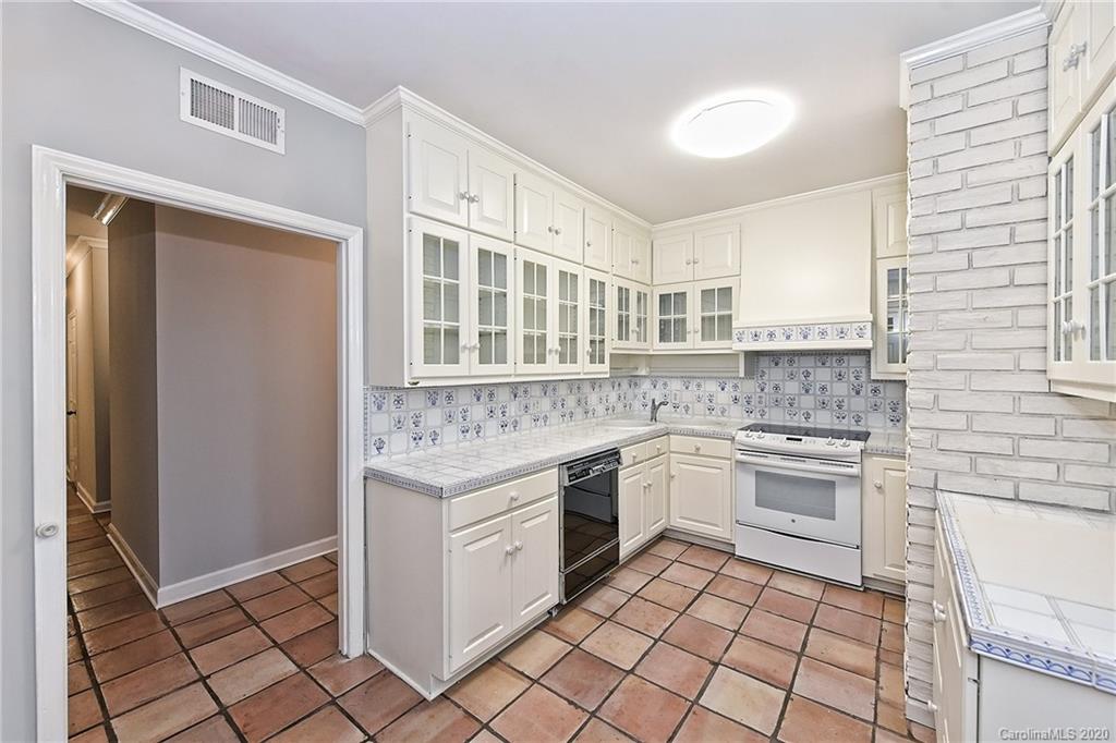 908 Cherokee Road, Unit 908 Charlotte, NC 28207 - Photo 4 of 35 a kitchen with a stove sink and cabinets