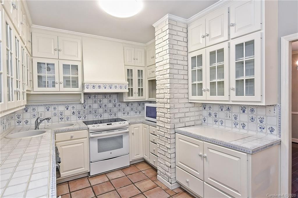 908 Cherokee Road, Unit 908 Charlotte, NC 28207 - Photo 8 of 35 a kitchen with granite countertop a sink stove and cabinets