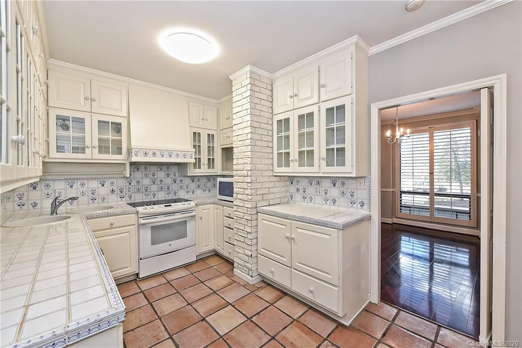 908 Cherokee Road, Unit 908 Charlotte, NC 28207 - Photo 9 of 35 a kitchen with granite countertop white cabinets and white appliances