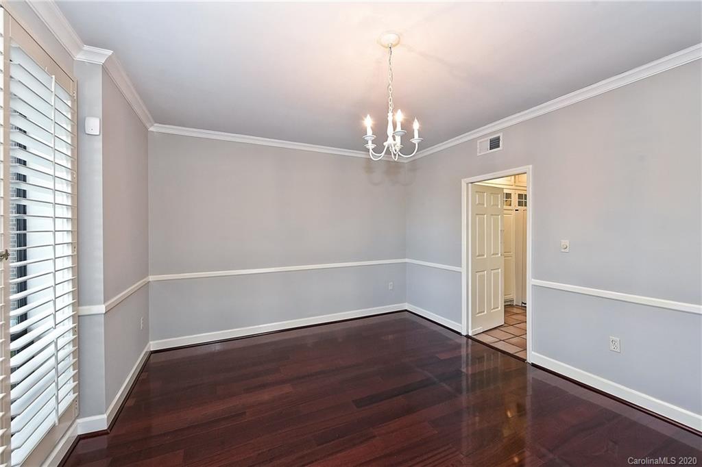 908 Cherokee Road, Unit 908 Charlotte, NC 28207 - Photo 10 of 35 an empty room with wooden floor chandelier and windows
