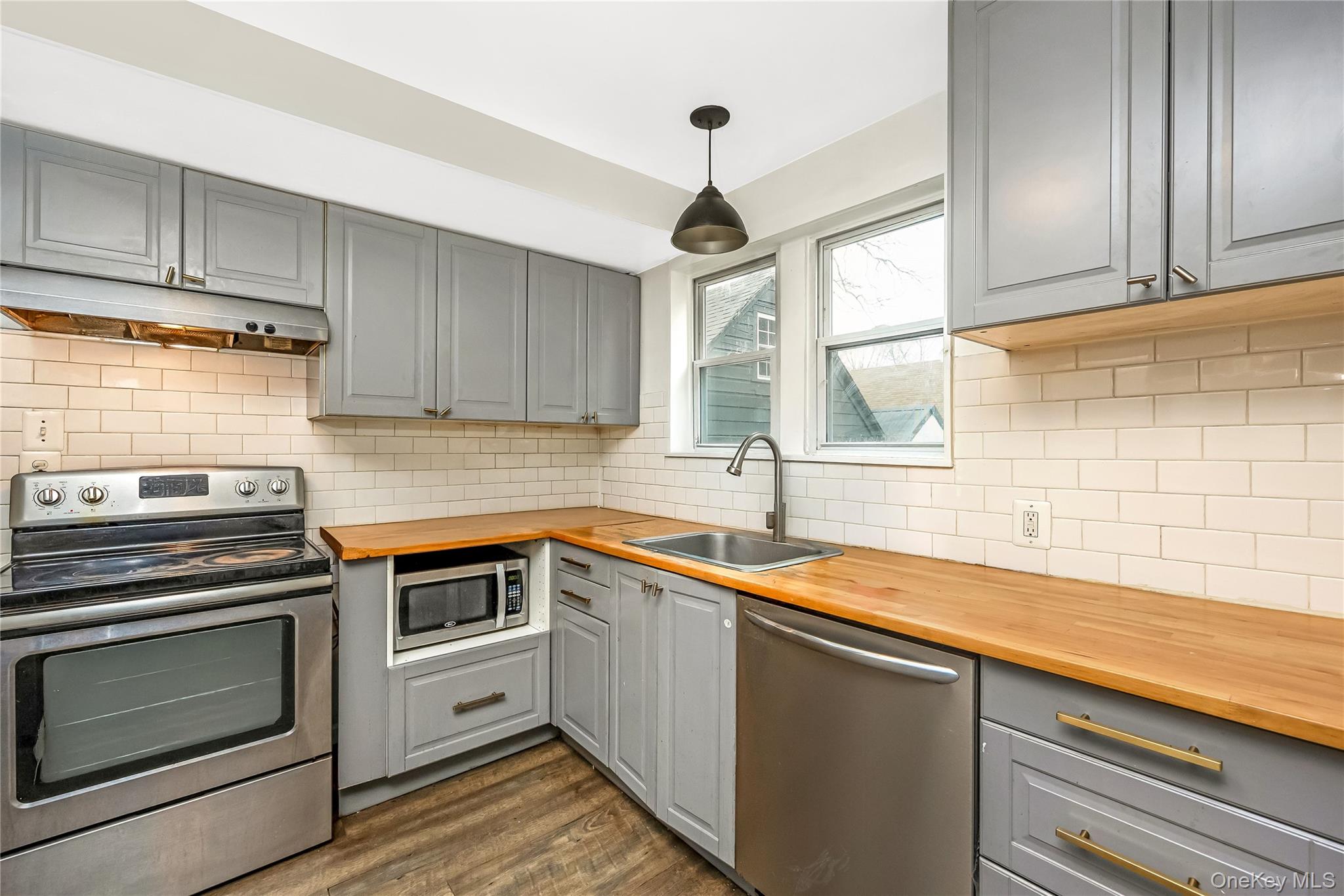 97 Berry Street Lindenhurst, NY 11757 - Photo 13 of 23 a kitchen with a sink stove and cabinets