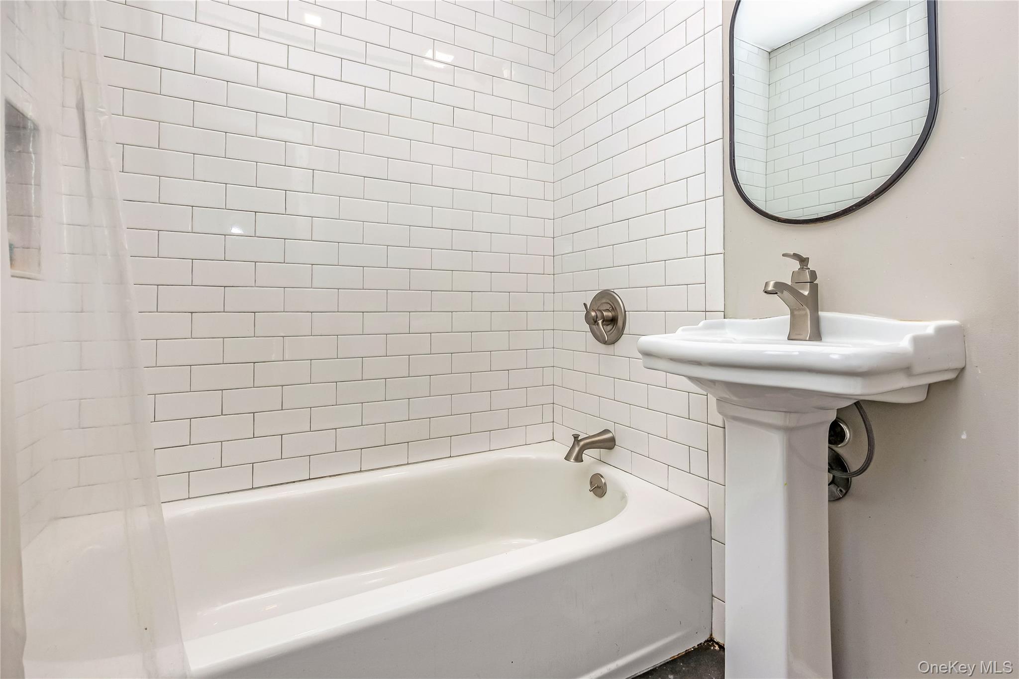 97 Berry Street Lindenhurst, NY 11757 - Photo 10 of 23 a bathroom with a sink a mirror and a bathtub