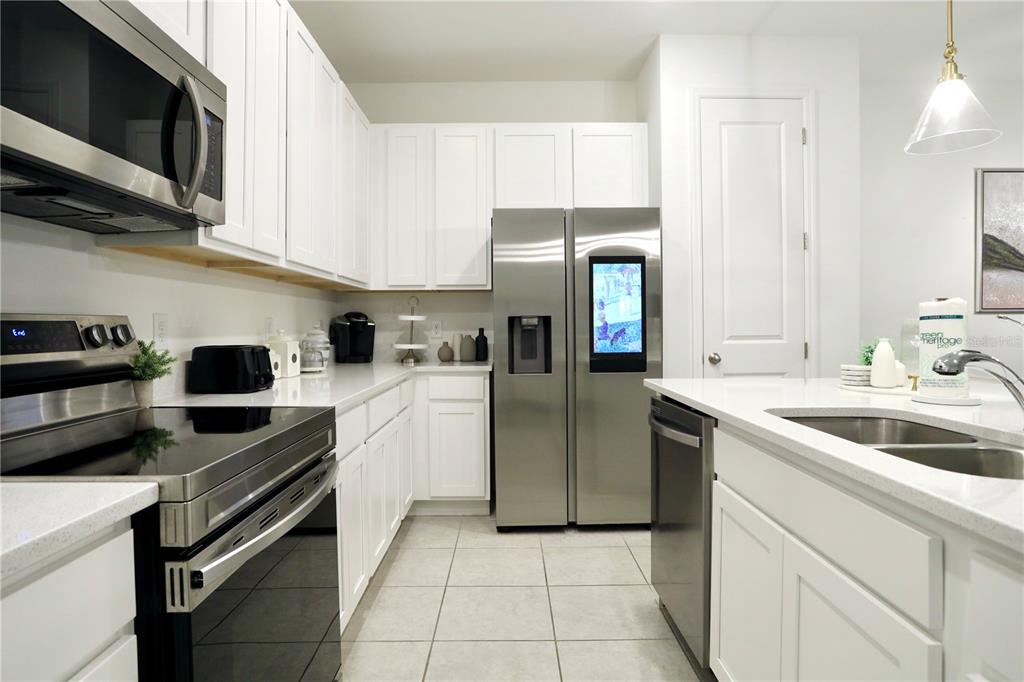 943 Conch Road Davenport, FL 33896 - Photo 11 of 43 a kitchen with a sink cabinets and stainless steel appliances