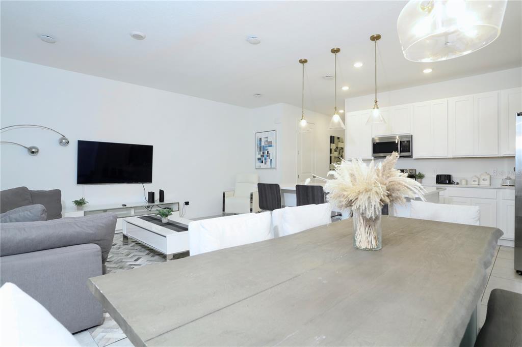 943 Conch Road Davenport, FL 33896 - Photo 13 of 42 a living room with furniture a flat screen tv and kitchen view