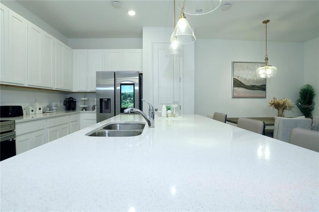 943 Conch Road Davenport, FL 33896 - Photo 16 of 43 a kitchen with stainless steel appliances a sink a counter top space cabinets and a wooden floor