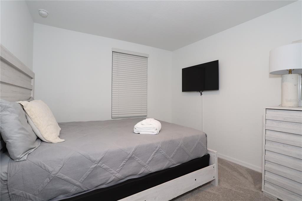 943 Conch Road Davenport, FL 33896 - Photo 23 of 43 a bedroom with a bed and a flat screen tv