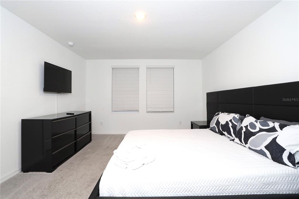 943 Conch Road Davenport, FL 33896 - Photo 25 of 42 a bedroom with a bed and a flat screen tv