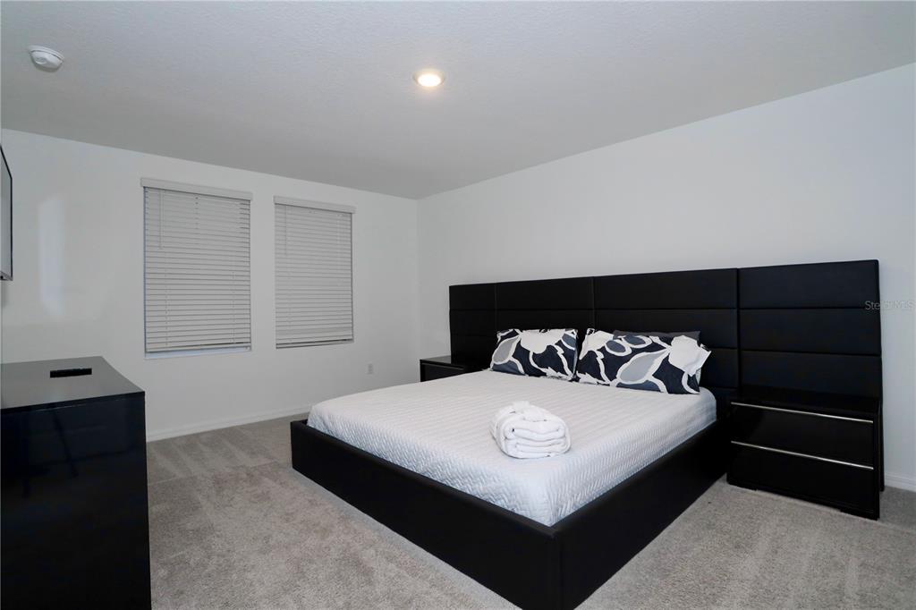 943 Conch Road Davenport, FL 33896 - Photo 27 of 43 a bedroom with a bed and a night stand