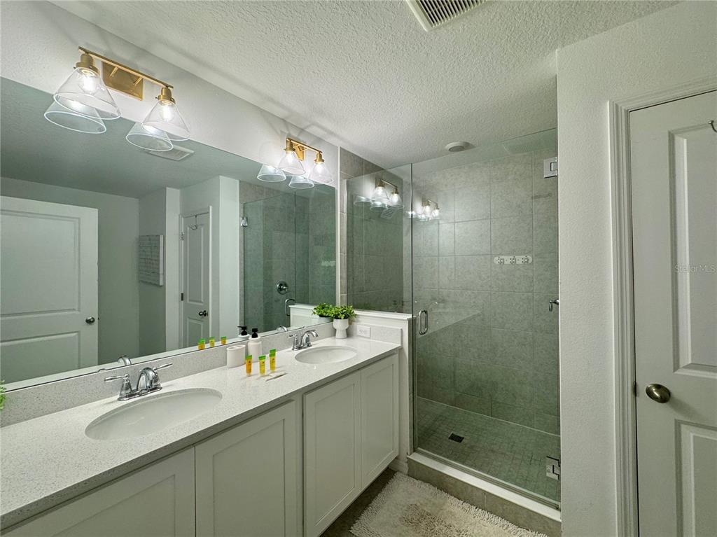 943 Conch Road Davenport, FL 33896 - Photo 29 of 43 a bathroom with a double vanity sink mirror and shower