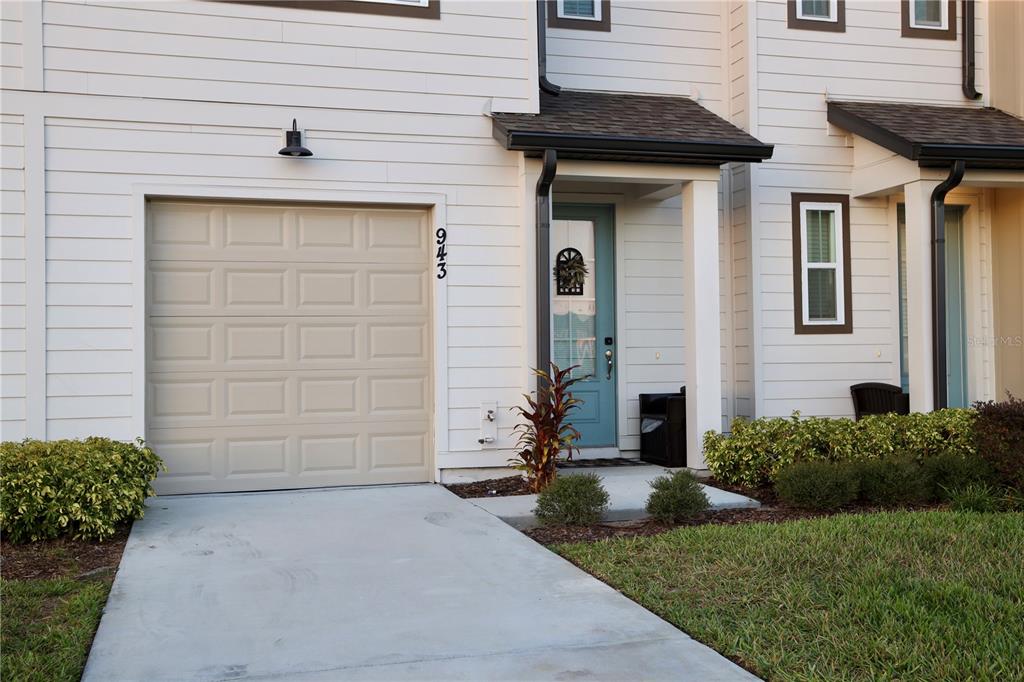 943 Conch Road Davenport, FL 33896 - Photo 32 of 42 a front view of a house with a yard and garage