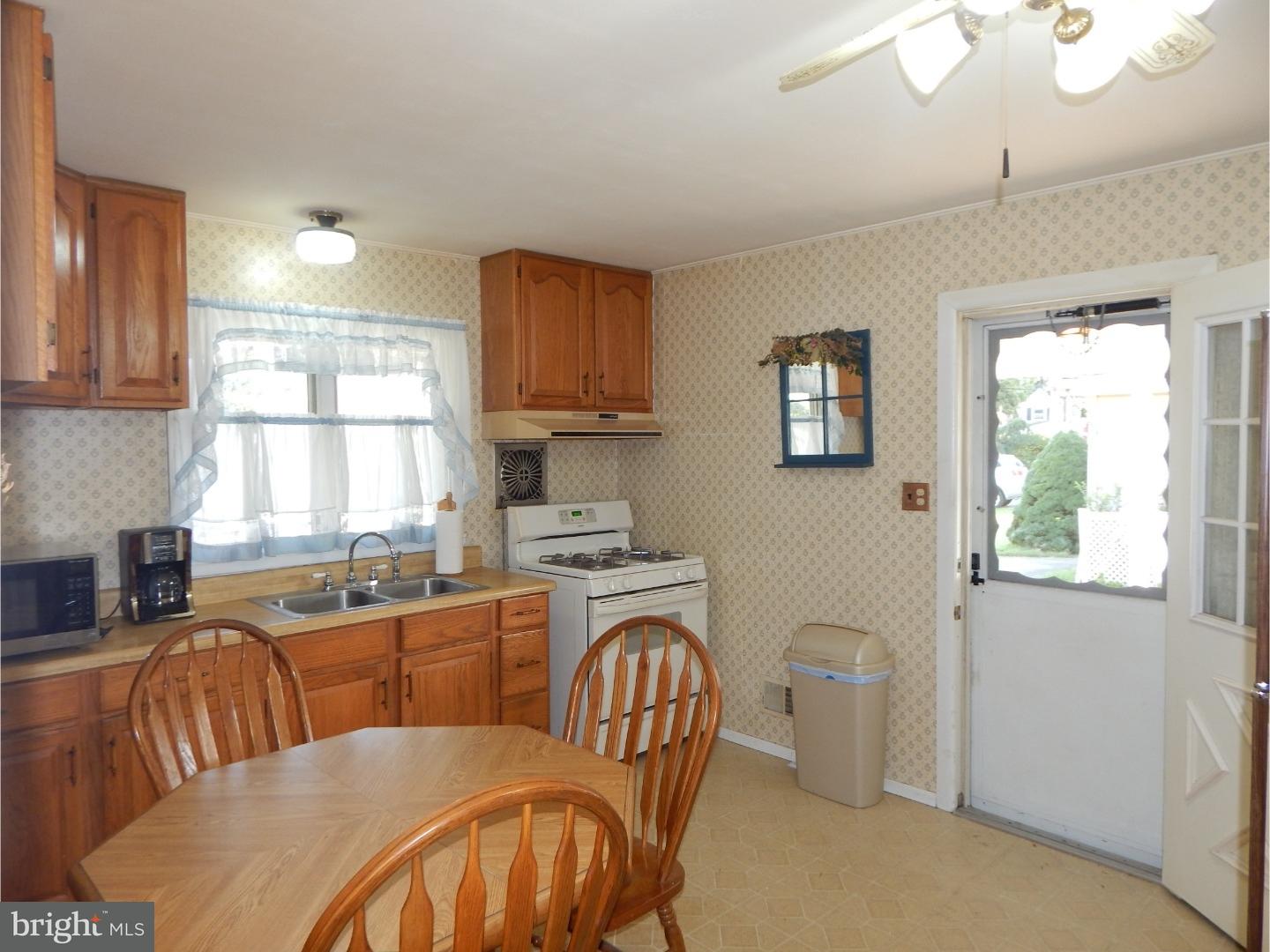 25 Downing Road Hamilton, NJ 08690 - Photo 3 of 14 a open kitchen with stainless steel appliances granite countertop a sink a stove a dining table and chairs with wooden floor