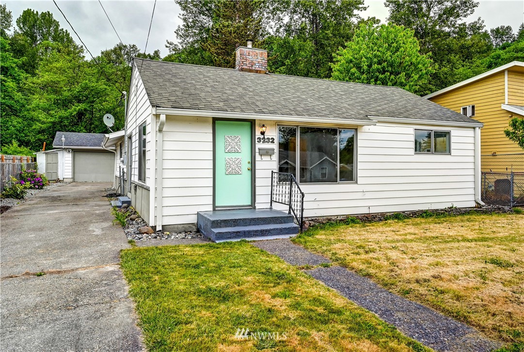 3232 Southeast 5th Street Renton, WA 98058 - Photo 1 of 20 a view of a white house with a small yard plants and large tree