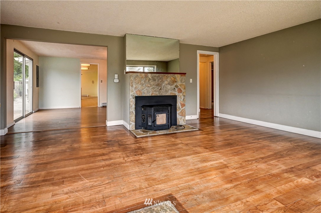 3232 Southeast 5th Street Renton, WA 98058 - Photo 2 of 20 a view of an empty room with wooden floor fireplace and a window